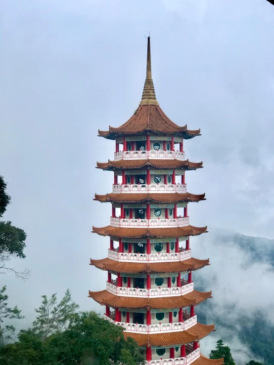 a pagoda with balcony in the foreground on top of a mountain