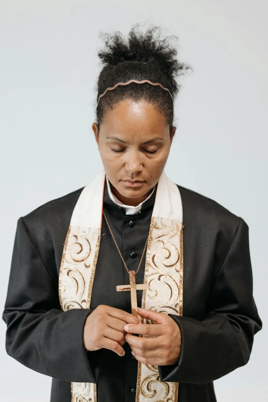 the woman is wearing a cross and black coat