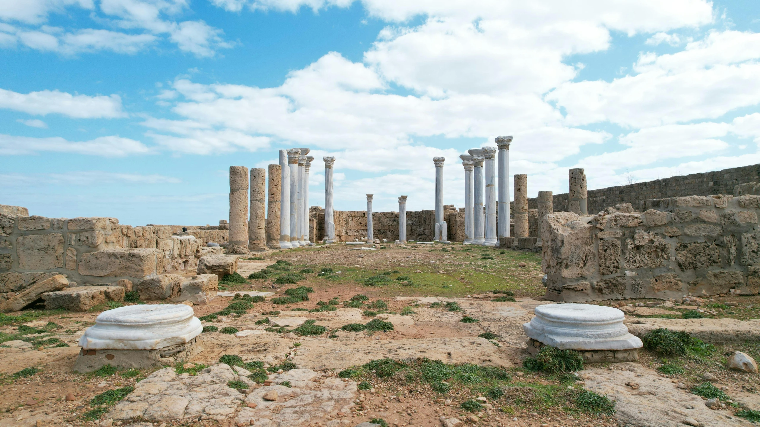 an old, crumbling building stands in a vast open field