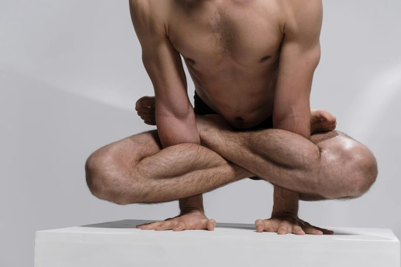 a man sitting in a yoga position on a box