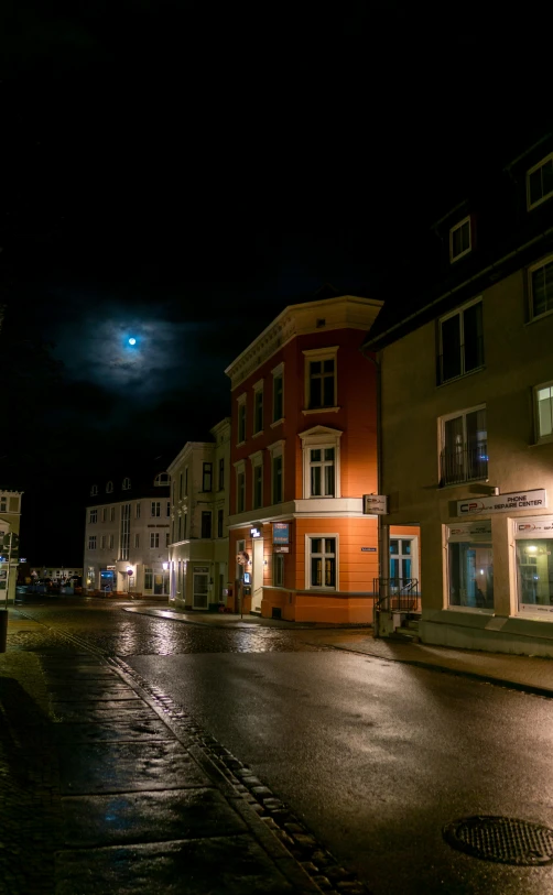 an empty street with buildings lit up at night