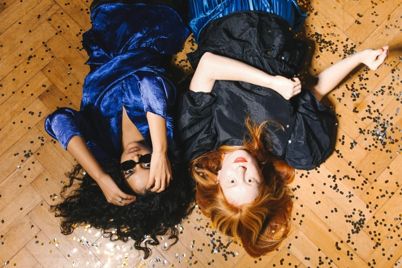 two girls are laying on the floor together
