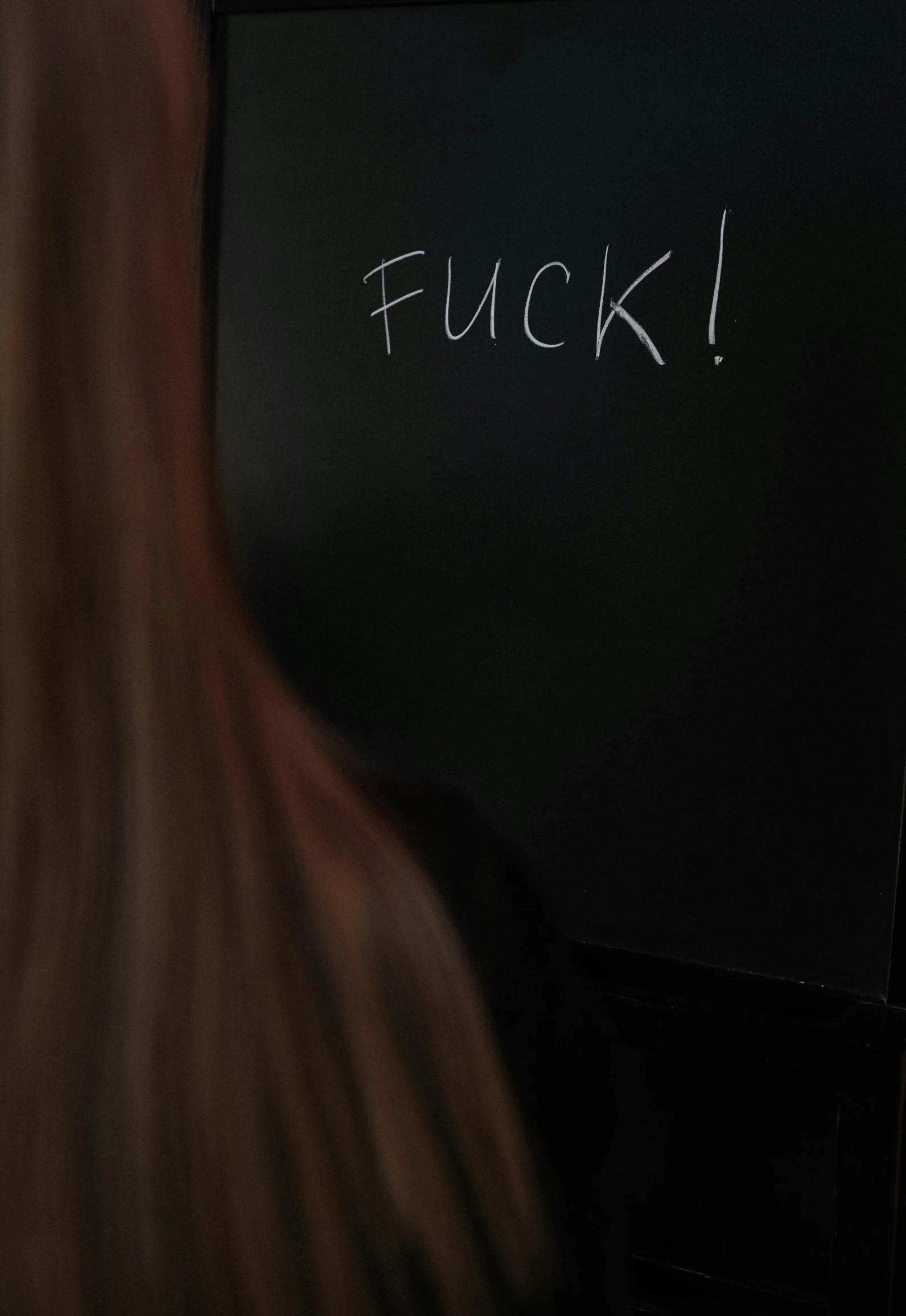 a woman in a black jacket writing on a fridge