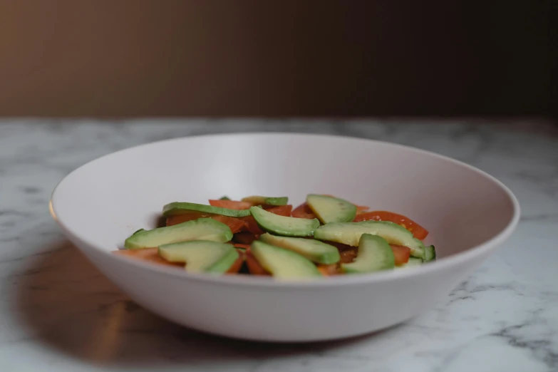 a small white bowl of assorted food items