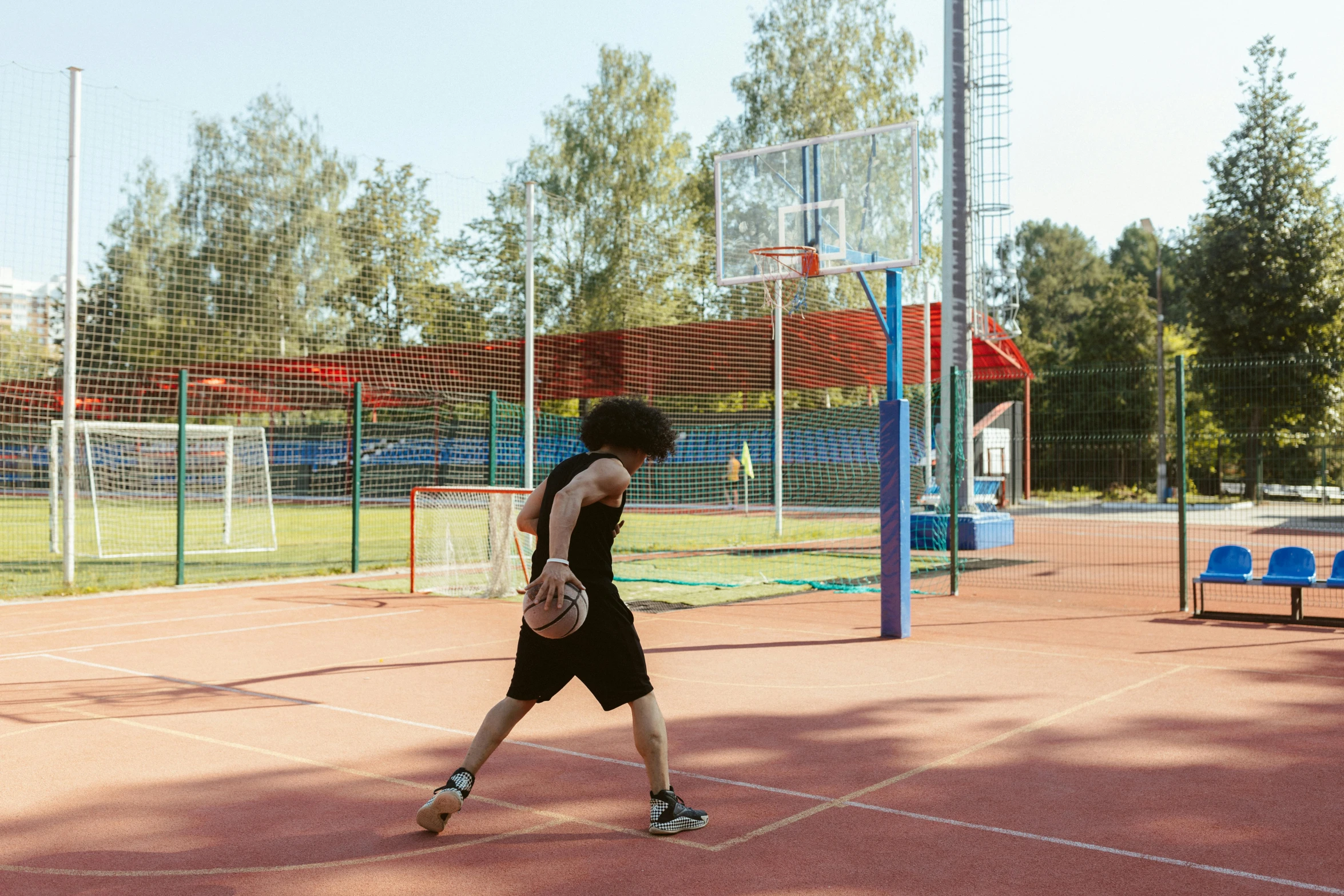 a person is walking on a court with balls