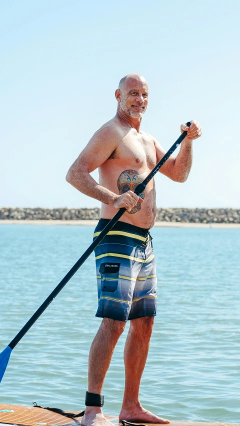 an older man is riding on a paddle board