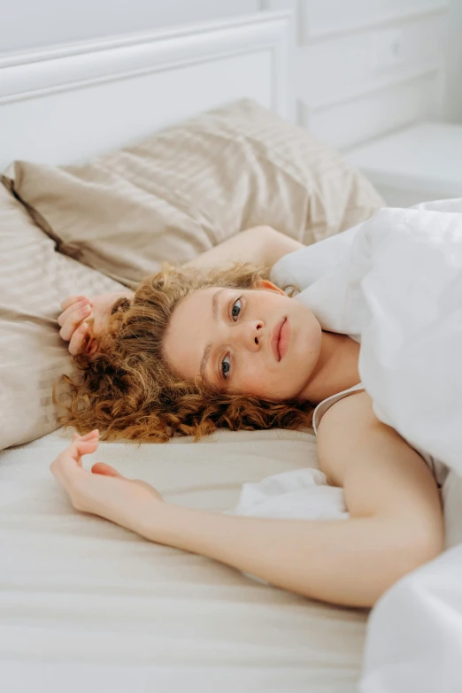  laying in bed wearing a white dress