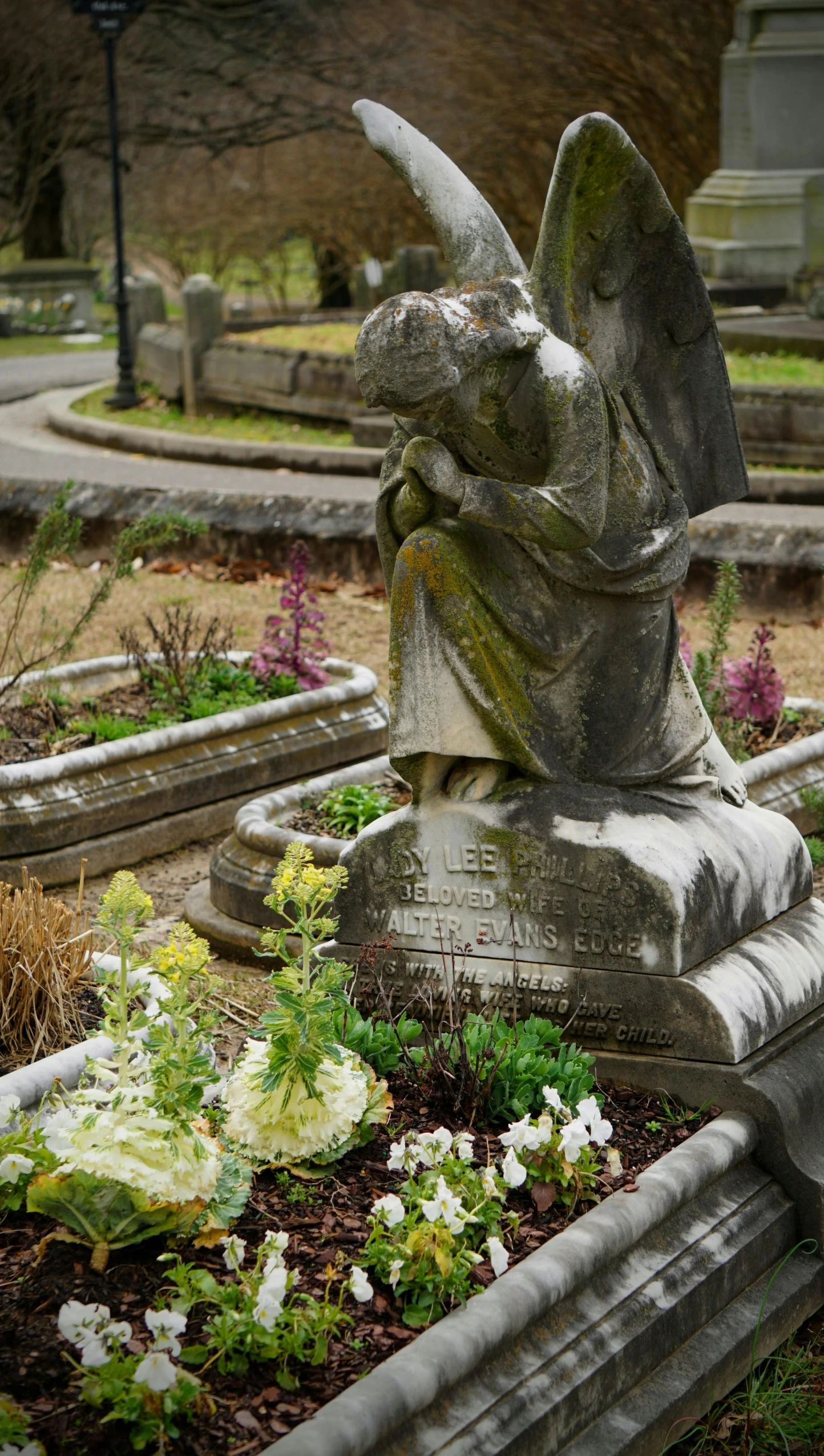 a statue holding an apple on top of a lush green garden