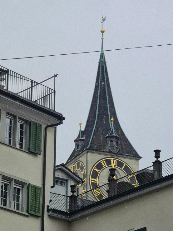 the roof of an old building has a clock tower with green shutters