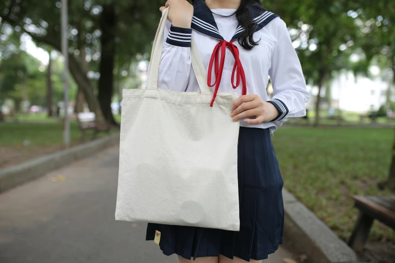 a woman in a white sailor's shirt holding up a white bag