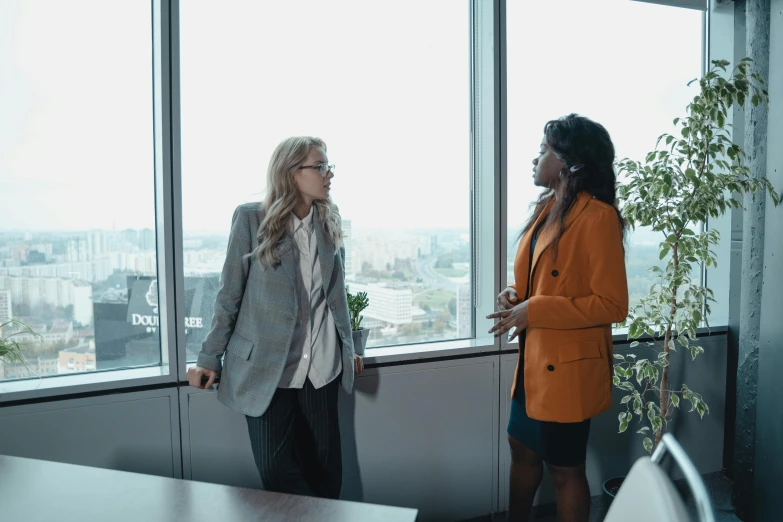 two woman are standing in front of an open window