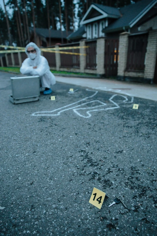 someone kneeling down on the road with a yellow marker