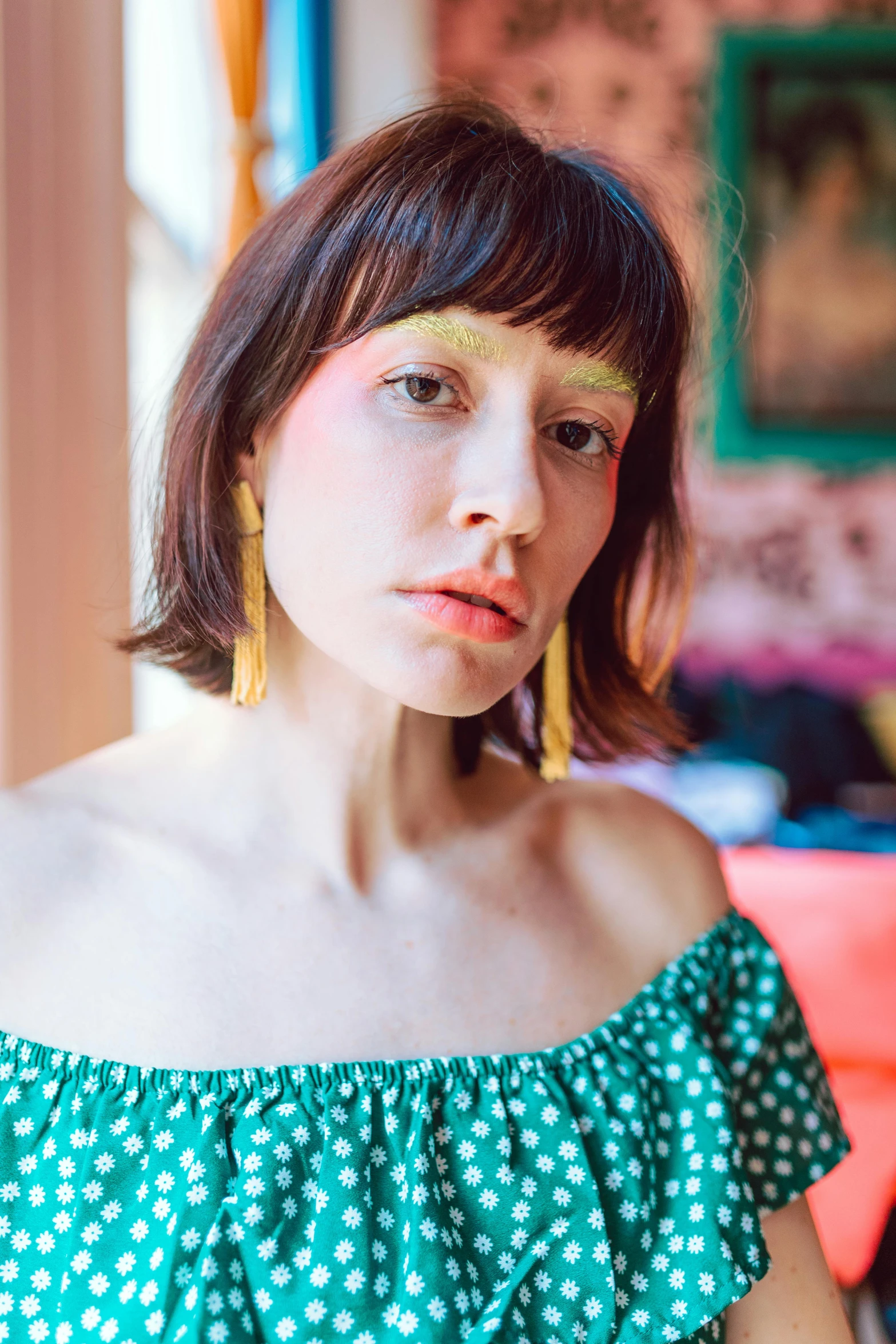 a woman wearing a green dress is looking at the camera