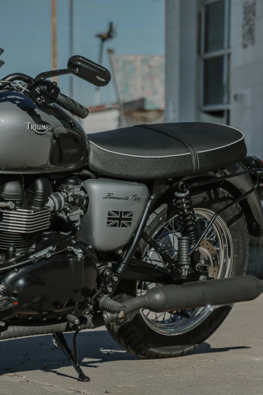 a motorcycle parked on a concrete driveway next to a building