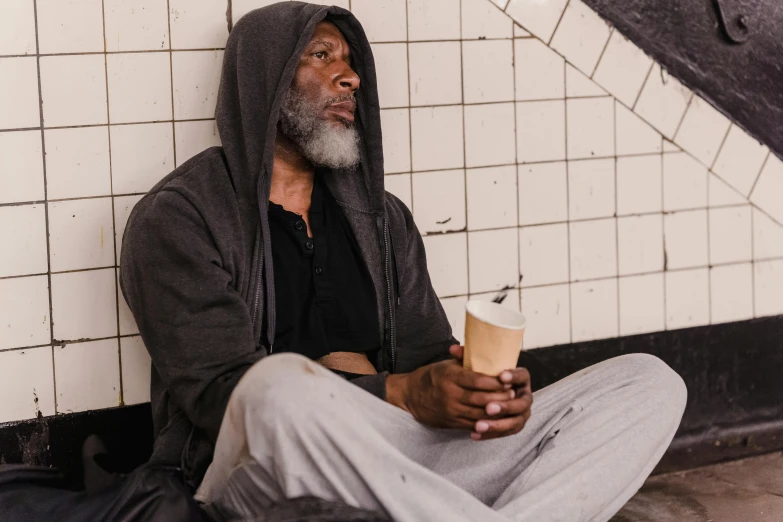 an old man with a grey beard sitting on a tile floor