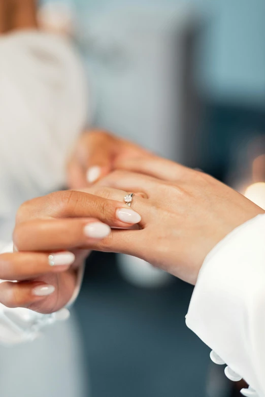 two people exchanging a gold wedding ring