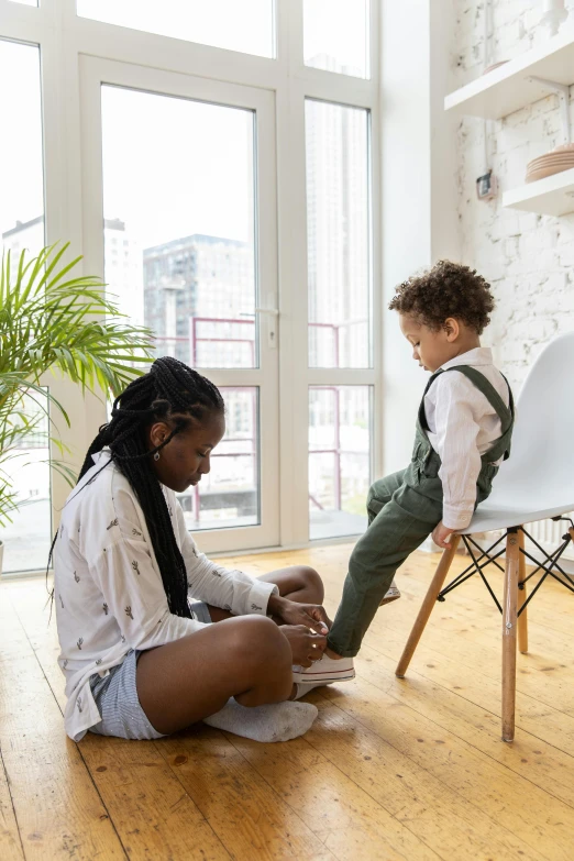 an adult woman sits on the floor with a child