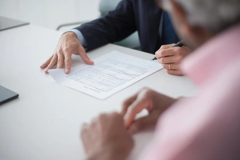 hands of a man and a woman at a table with papers