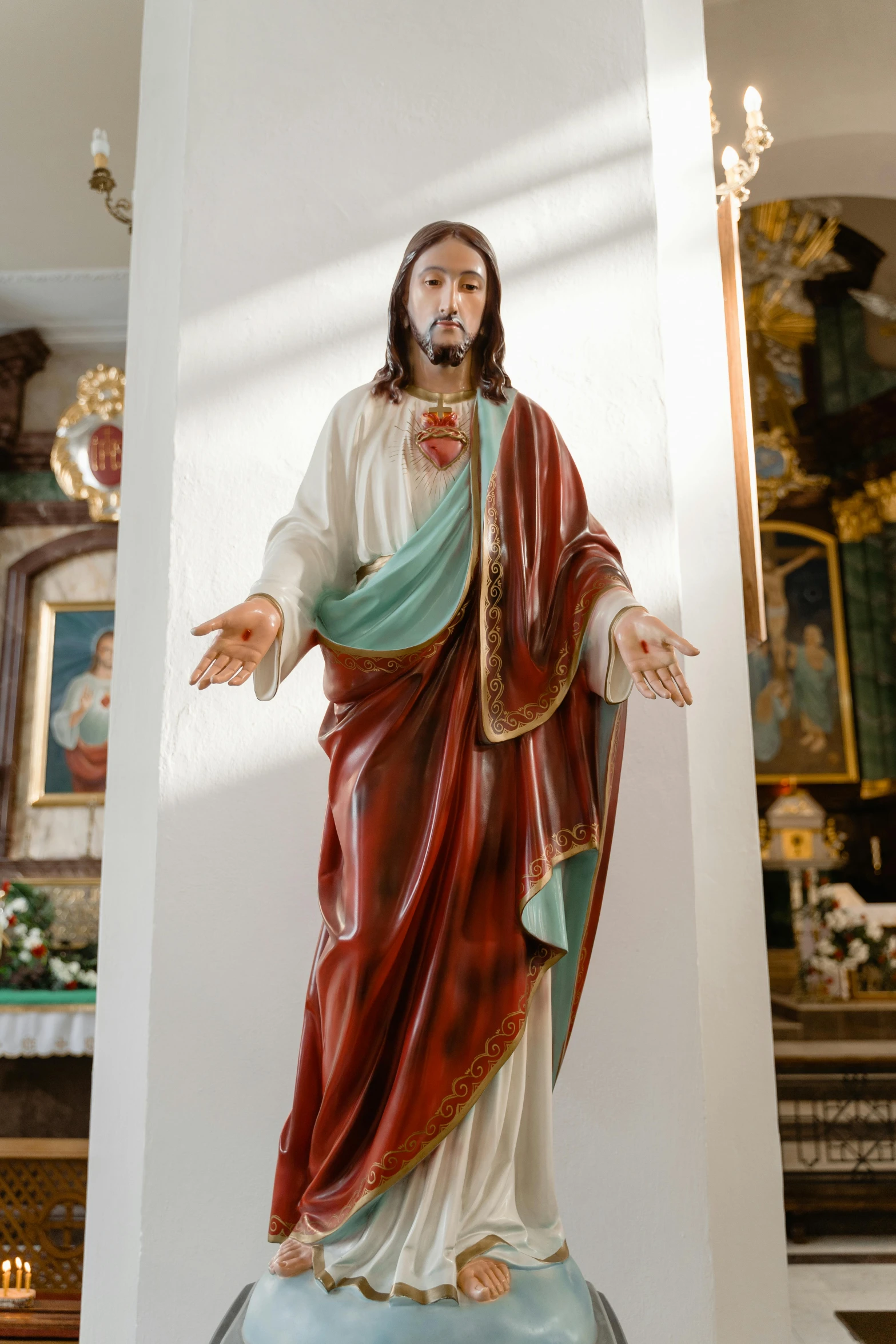 a statue of jesus in a church surrounded by paintings