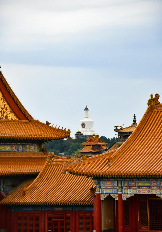 two pagodas in front of a building that has golden roof