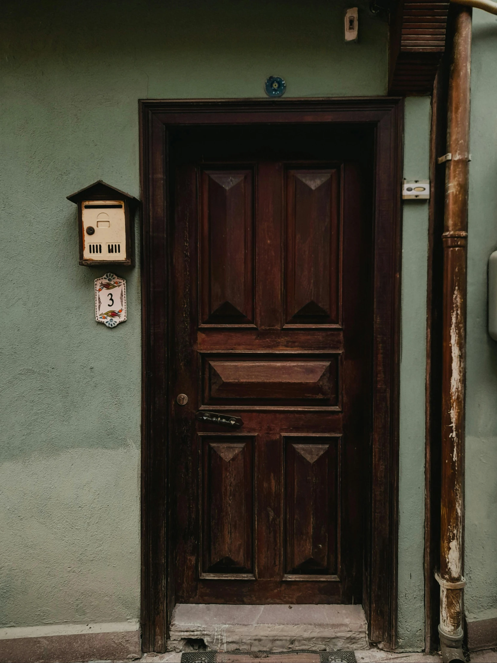 a wooden door next to an electrical box