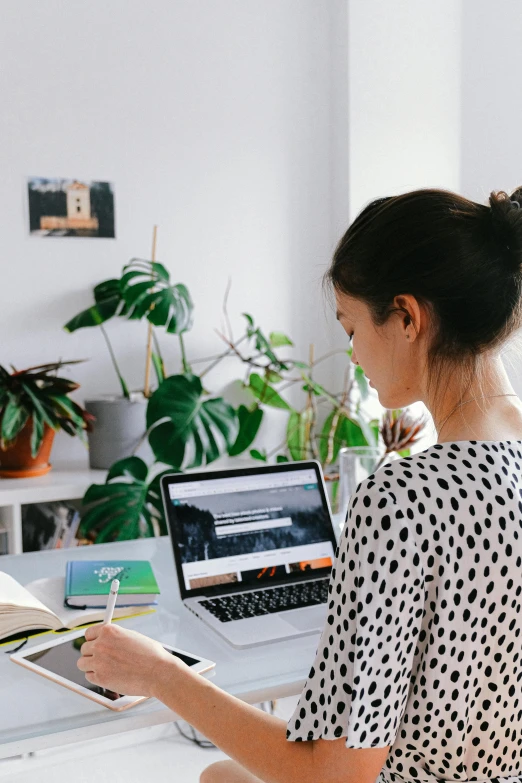 a woman looking at a book on the computer screen