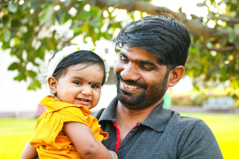 a man smiles with his young daughter