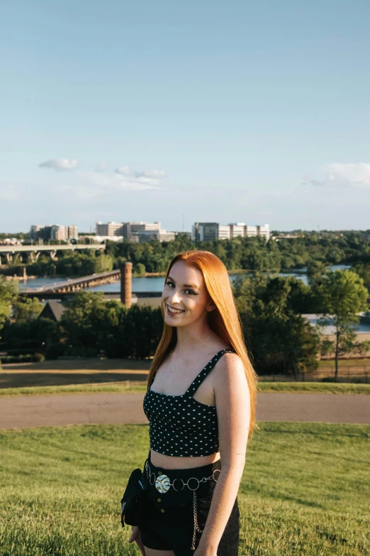 young lady in skirt posing with buildings in the background