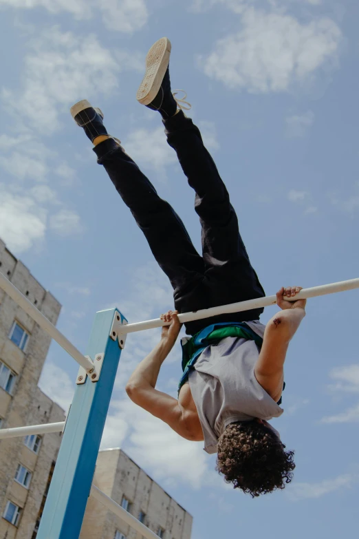 a young man is performing a high jump in the city