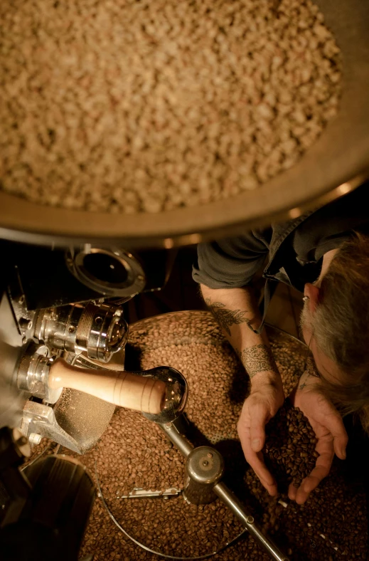 there is a man using a machine that produces grains from seed