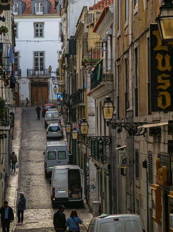 a narrow cobblestone road in europe with people and cars