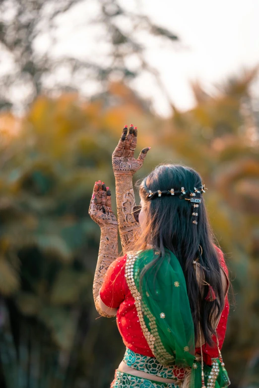 woman in colorful dress waving her hands to the sky