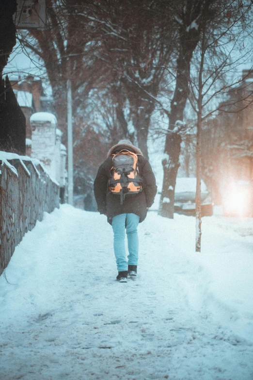 someone walking through the snow carrying their backpack