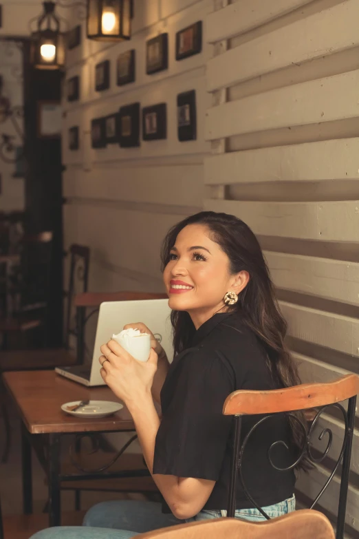 a woman sitting in a chair drinking a beverage