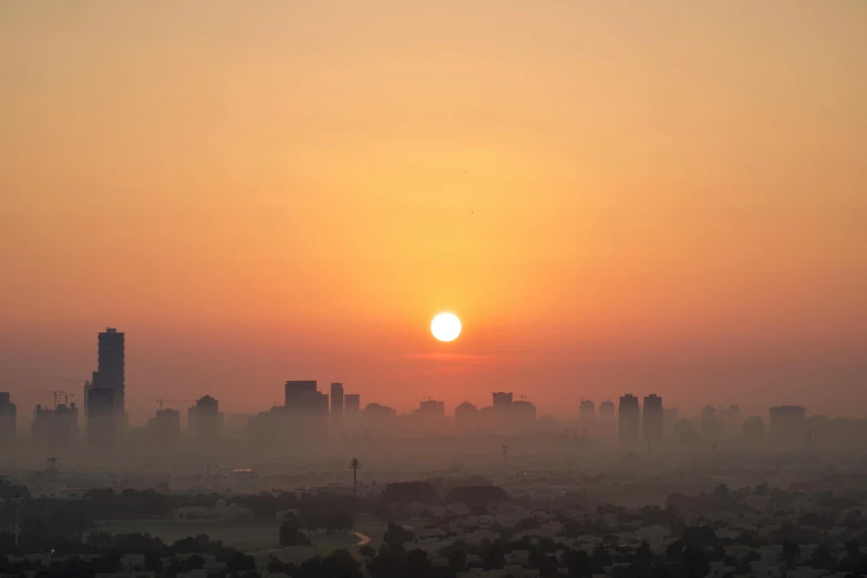 sun setting over a large city with skyscrs