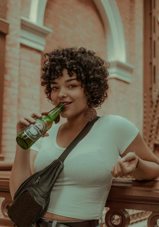 a woman holding a beer is drinking some beer