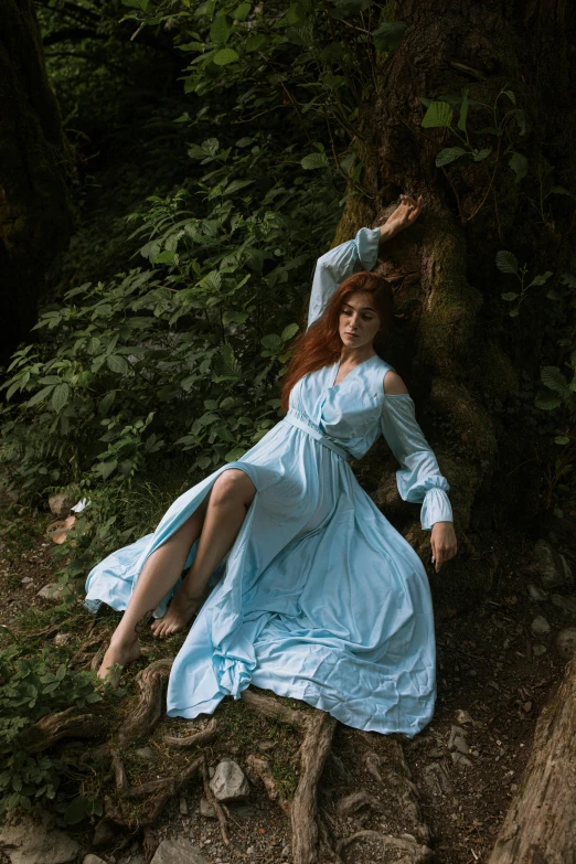 an image of a woman laying on the ground near trees