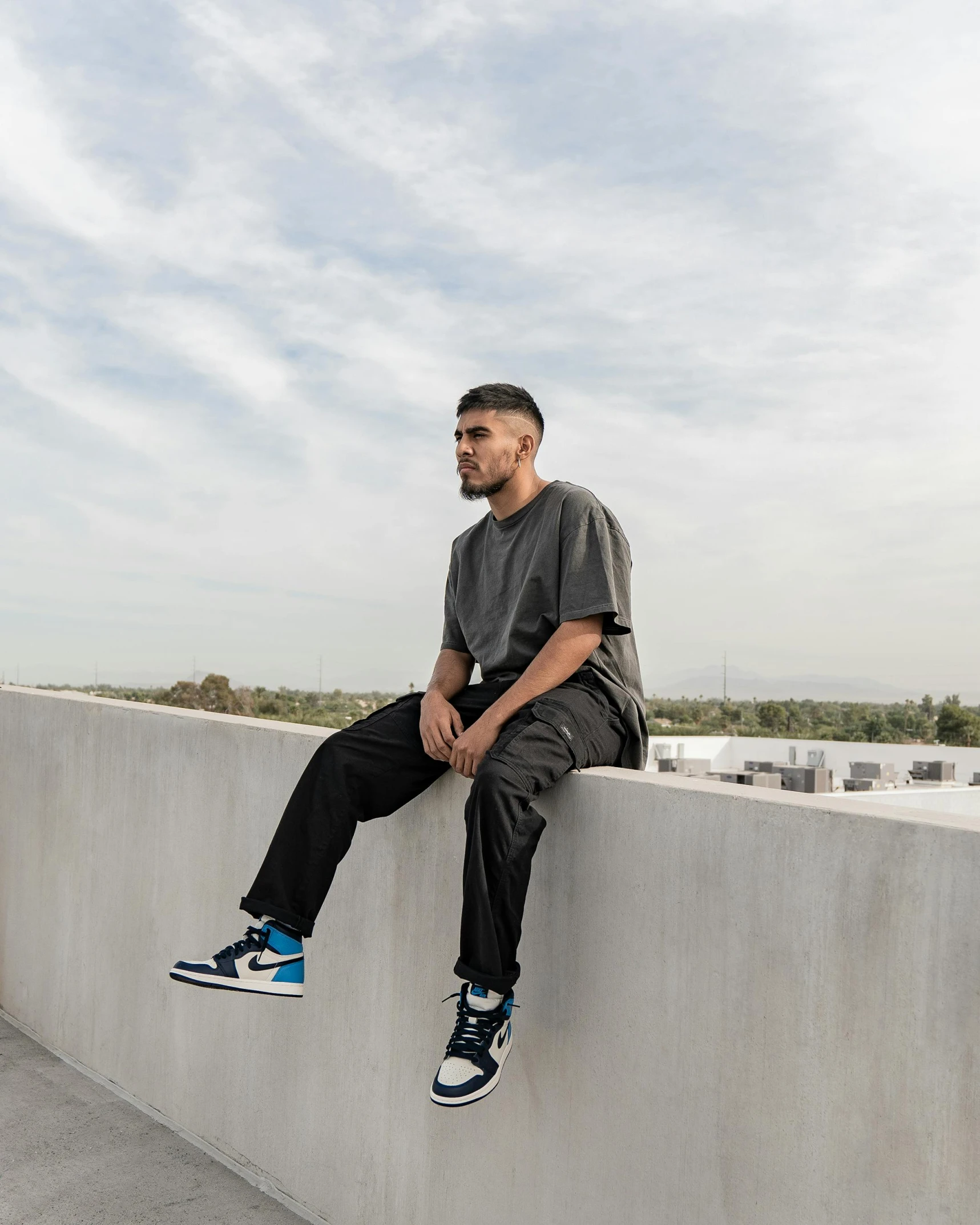 a man is sitting on the ledge while staring off