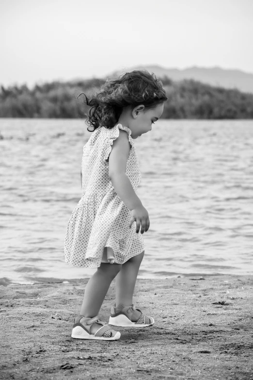 a little girl that is walking by a water way