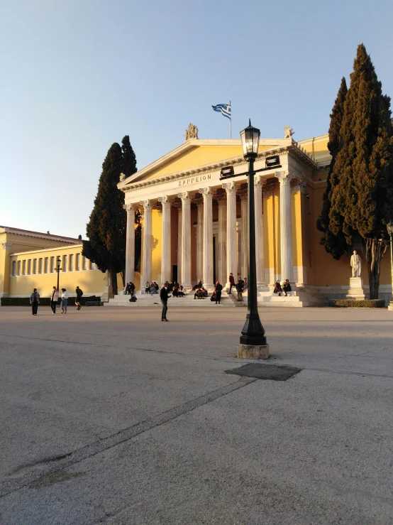 a yellow building with columns and a lamp post