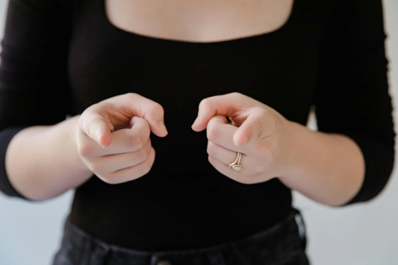 a woman in black top holding a ring in both hands