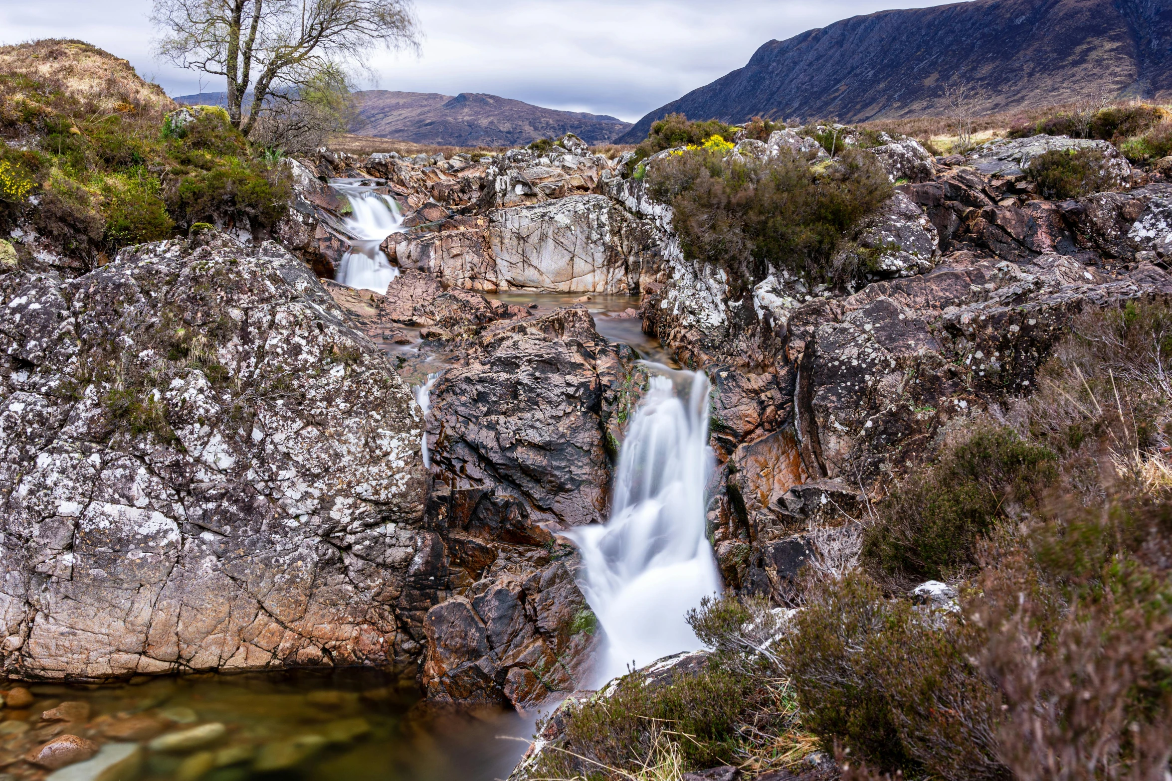 there is a waterfall flowing down this mountain side