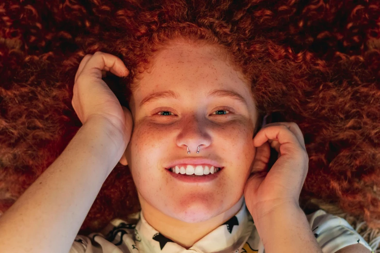 a girl with red hair smiling for a picture