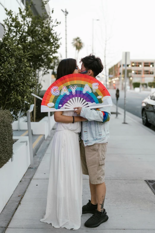 two women hug each other by the sidewalk