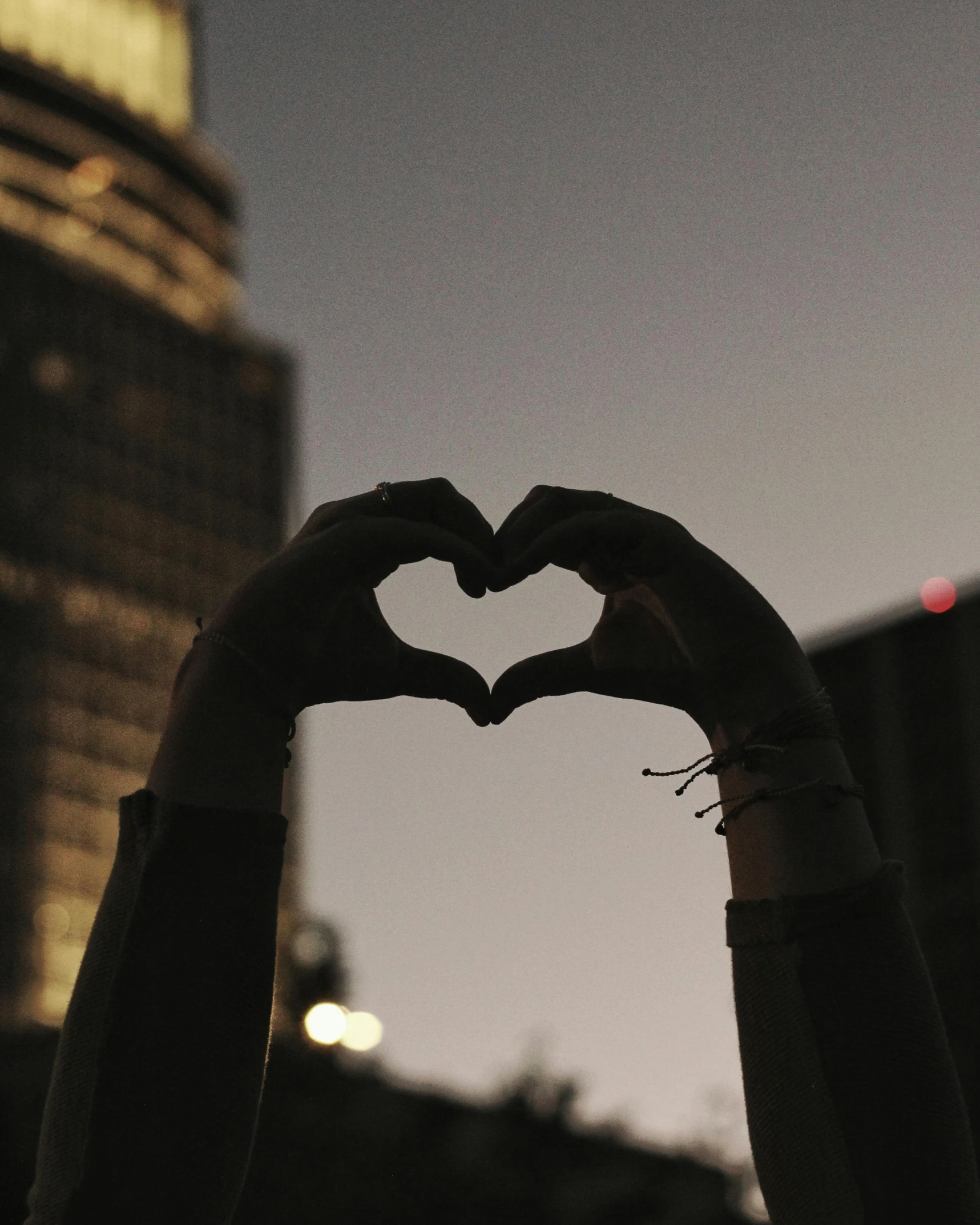 someone making the shape of a heart with their hands