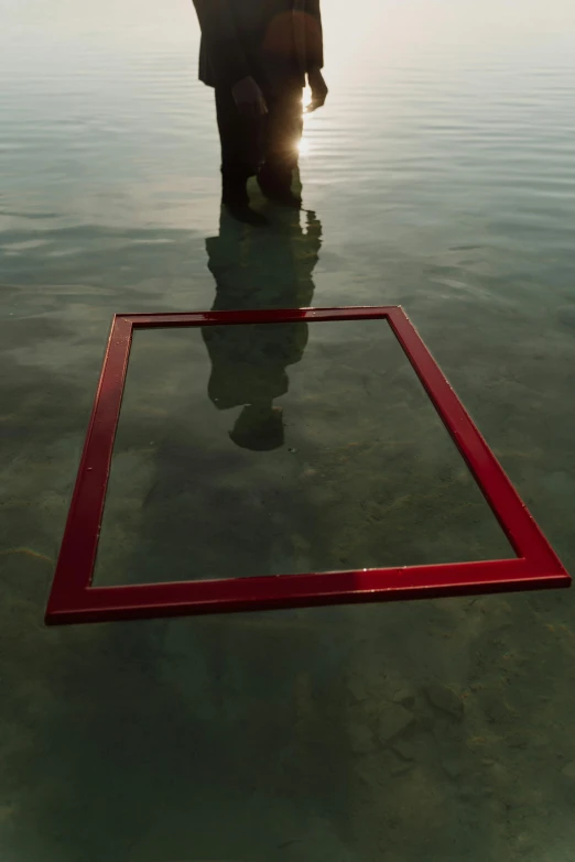 a person standing behind an object in the water