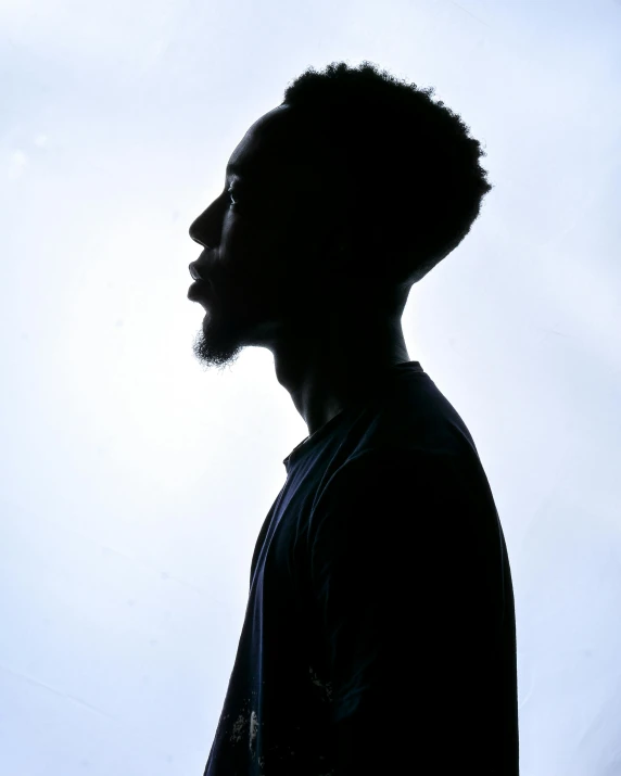 the silhouette of a man with a mustache looking away