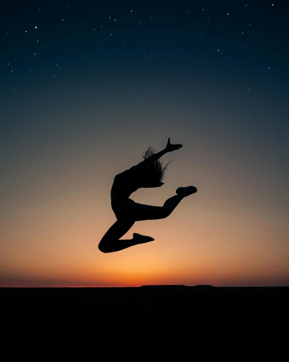 a silhouette of a woman jumping into the air