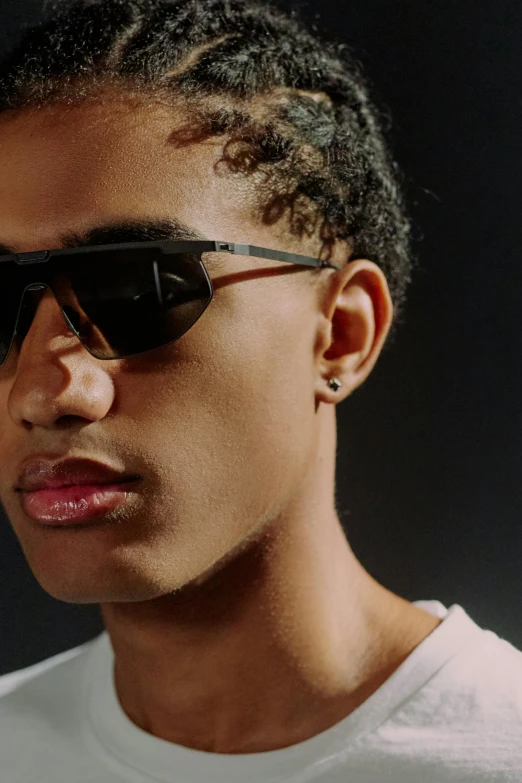 man with white tshirt and sunglasses on dark background