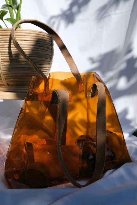 a clear handbag with a tan handle sitting on a table